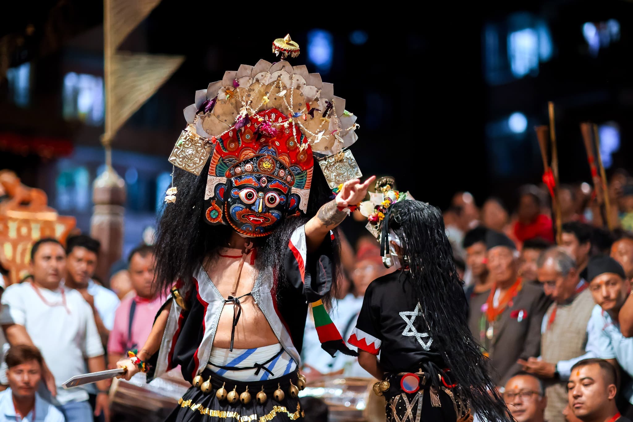 Festival route atmosphere with a masked Bhaila performance in Thimi.